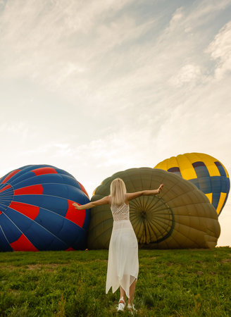 Amazing view with woman and air balloon. Artistic picture. Beauty world. The feeling of complete freedomの写真素材