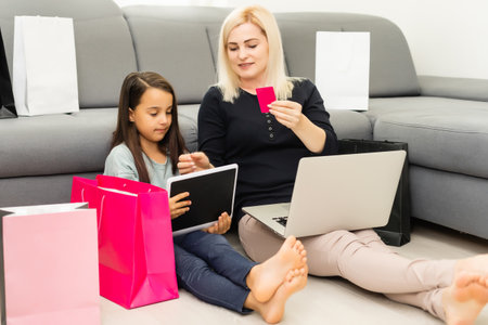 Mother and daughter shopping on internetの写真素材