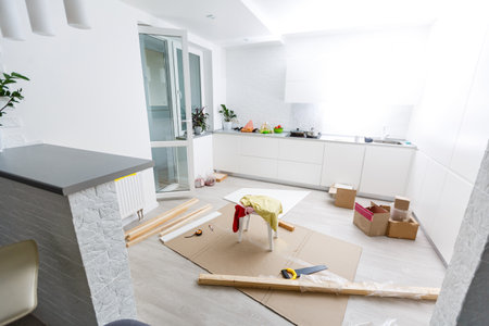 Wooden shelves laying on round table and senior man crafting furniture at apartment balcony. House improvingの写真素材