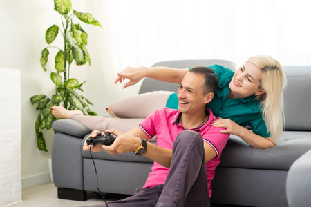 Couple playing video games at home