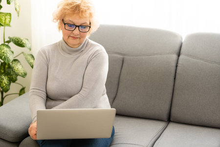 Video call. Good-looking elderly lady i having a video call on laptop