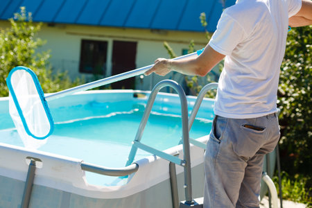 man cleaning the pool at her country house. Summer at home concept. Lifestyleの写真素材