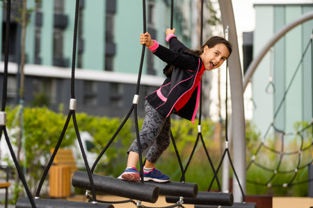 Little girl having fun playing on the sports groundの写真素材