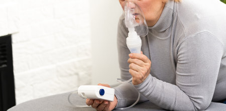 Senior woman making inhalation, elderly woman and nebulizerの写真素材