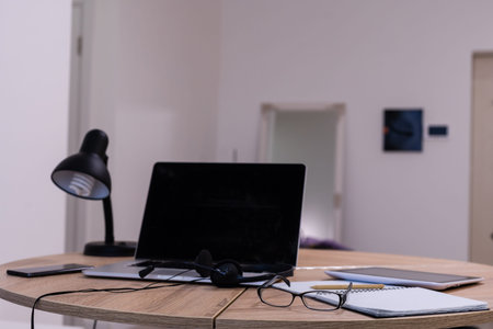 Modern office workspace with laptop computer, tablet pc and smartphone on the desk. There is a...