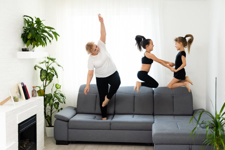 grandmother and children exercising workout at home near the window in roomの写真素材