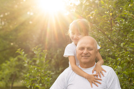 Portrait Of Grandfather With Granddaughter Relaxing Together in the gardenの写真素材
