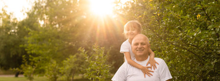 Little girl spending time with grandfather in the park.の写真素材