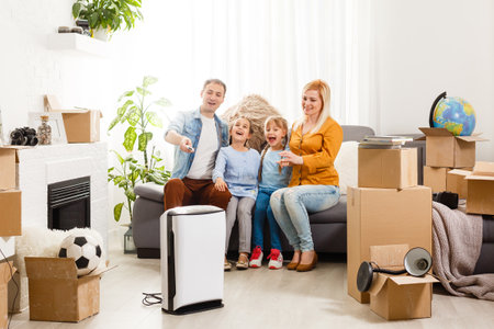 air purifier in living room with happy family moving to new apartmentの写真素材
