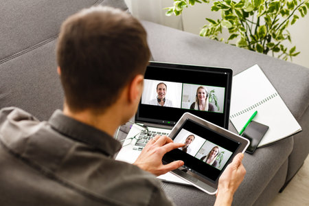 Man having video conference with friends on laptop at home