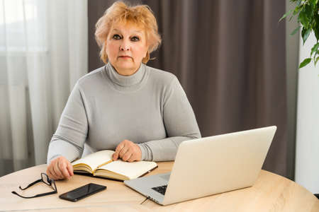 Head shot mature woman looking at camera and talking, grandmother chatting with relative online, making video call, middle aged blogger recording vlog, teacher speaking to webcam, distance lectureの写真素材