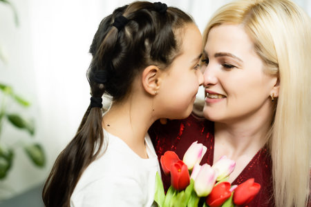 Woman and child with bouquet of flowers against home background. Spring family holiday concept....