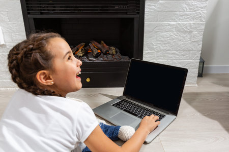 Kids distance learning. Cute little girl using laptop at home. Education, online study, home...