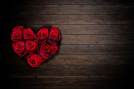 Heart shaped red roses bouquet on rustic wooden backgroundの写真素材