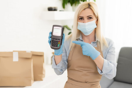masked blonde girl with pos terminal