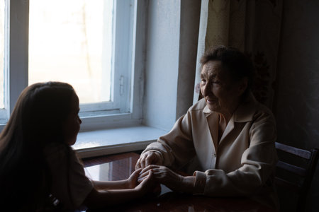 very old woman holding the hands of a childの写真素材