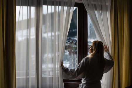 Young woman with a view of the winter mountain landscapeの写真素材