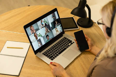 Woman having video chat with colleagues at laptop in office, closeupの写真素材