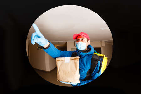 delivery man send food bag at door knob for contactless or contact free from delivery rider in front house for social distancing for infection risk.の写真素材