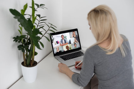 Back view of business woman talking to her colleagues about plan in video conference. business team...