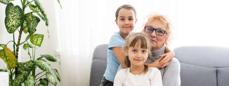 Closeup summer portrait of happy grandmother with grandchildren outdoors at homeの写真素材