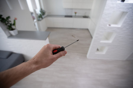 Locksmith maintenance work. The master holds a key and a screwdriver in his hand