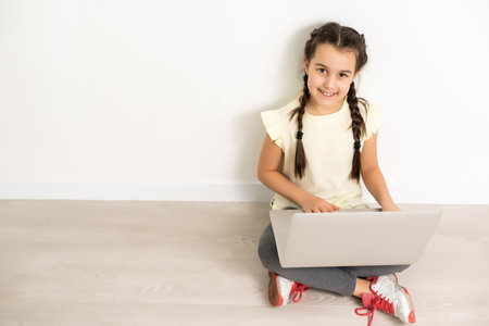 Little funny girl with laptop on white backgroundの写真素材