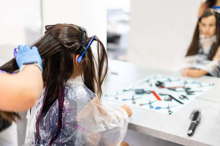 little girl dyes her hair purple in a hairdressing salonの写真素材