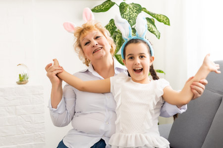 Happy easter. A grandmother and her granddaughter painting Easter eggs. Happy family preparing for...