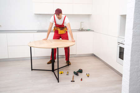 Young man assembling kitchen furniture.の写真素材