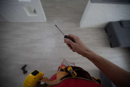 Locksmith maintenance work. The master holds a key and a screwdriver in his handの写真素材