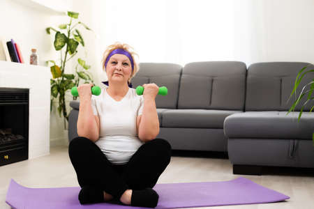Senior woman doing physical exercises with a dumbbellの写真素材