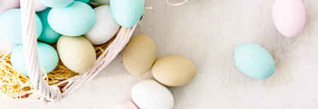 Easter eggs in nest on color wooden background