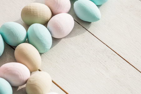 Coloeful easter eggs in nest on pastel color background with space.