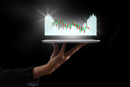 Business man holding tablet and showing holographic graphs and stock market statistics gain profits....