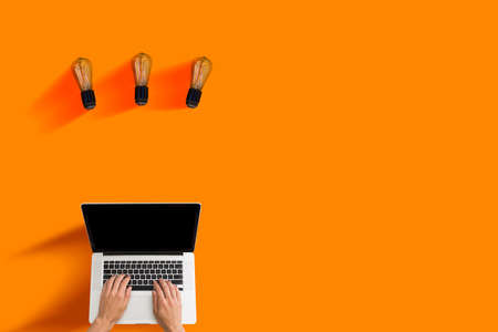 Idea Concept. Unrecognizable businessman holding illuminated light bulb at workplace in office, got business solution, closeupの写真素材