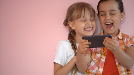 people, children, technology, friends and friendship concept - happy little girls with smartphones...