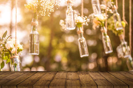 wooden table decor. The banquet area hang garlands of lights entwined with green plant. Wooden stand with lights and greenery. With the lights behind.の素材 [FY310165055237]