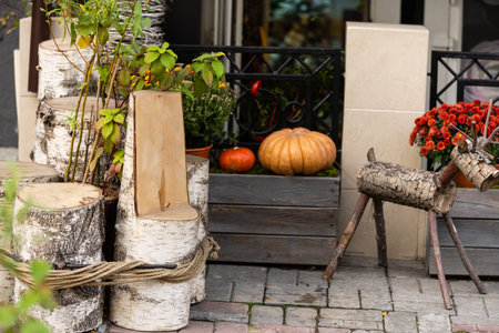Autumn decor with natural straw bale, pumpkins, flowers.
