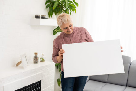 elderly woman holds a photo canvas