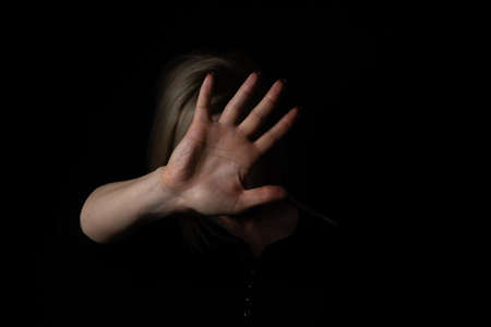 woman with raised hand on black background. isolated on black backgroundの写真素材