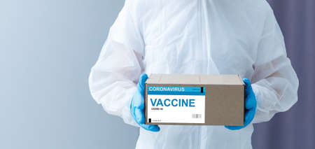 the man delivers the vaccine. Placing VACCINE label on the cardboard boxの写真素材