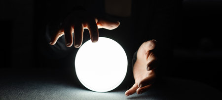Concept of occult sciences. Womens hands on a ball to guess the futureの写真素材