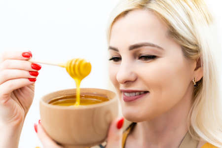closeup of woman and spoon with honey on white backgroundの写真素材
