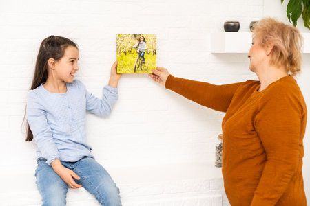 Canvas print. little girl and grandmother with photo canvasの写真素材