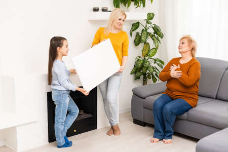 little girl mother and grandmother with blank empty photo canvasの写真素材