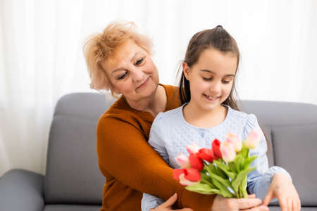 The little granddaughter congratulated her grandmother on International Womens and Mothers Day. A happy family. The concept of gratitude, love, well-beingの写真素材