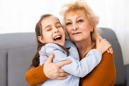 Lovely little girl with her grandmother looking at the cameraの写真素材
