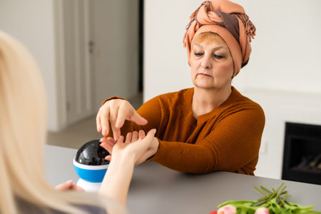Female Fortuneteller or esoteric Oracle, sees in the future by looking into their crystal ball during a Seance to interpret them and to answer questionsの写真素材