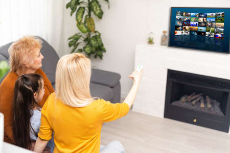 little girl mother and grandmother with remote controlの写真素材